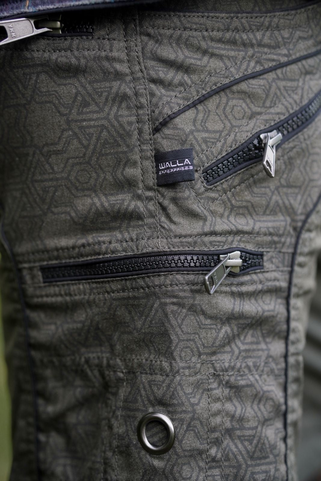 mens green above knee shorts close up YKK zipper detail geometric texture