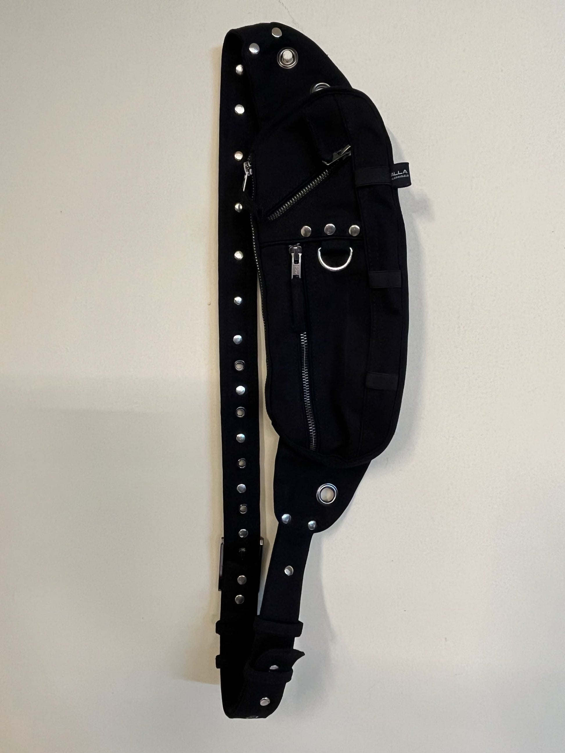 Black unisex crossbody bag with a Gothic Post-Apocalyptic design, featuring multiple zippers and brass buckles, displayed against a white background.